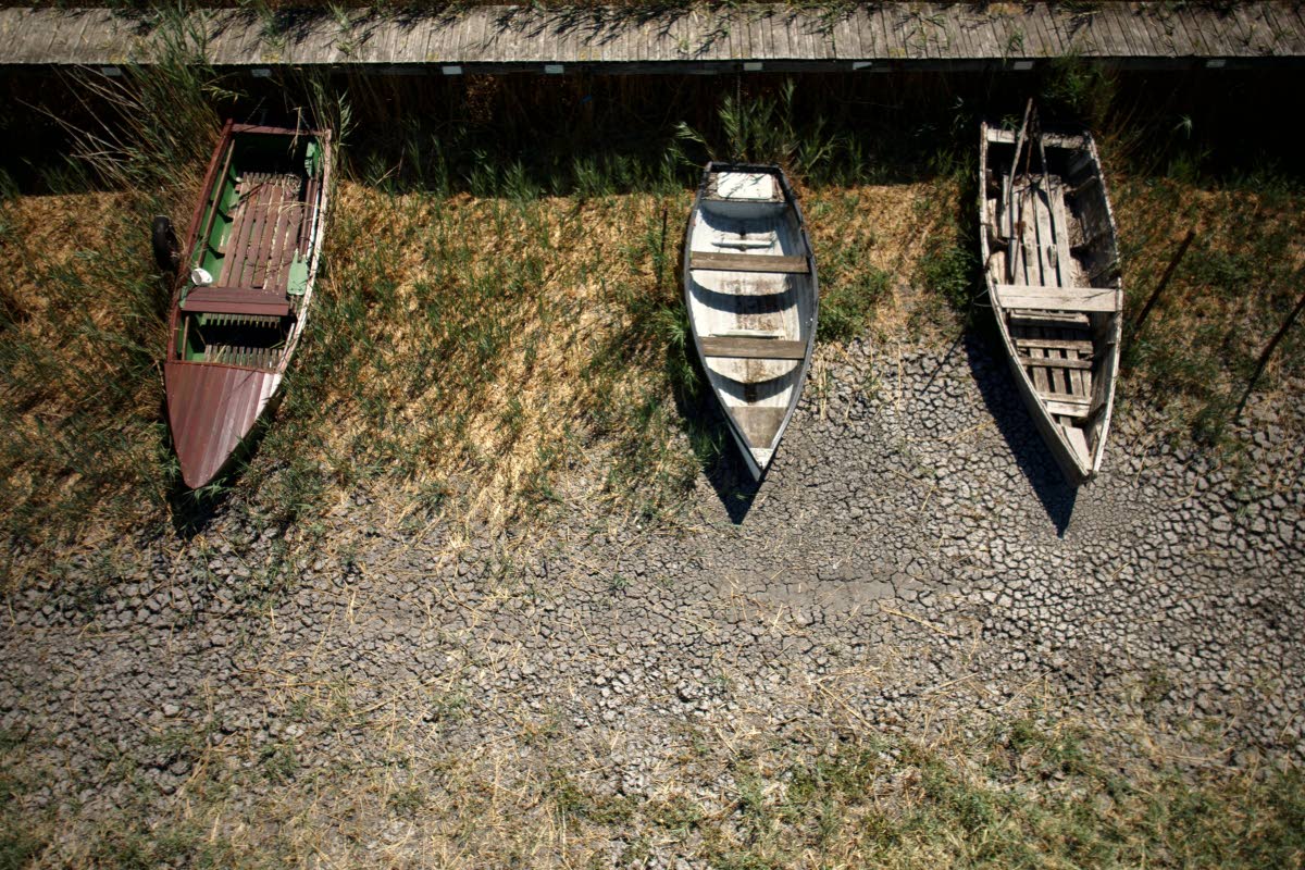 Boats lie on cracked soil at a dried-out marina on Lake Velence, Hungary, on August 13. 2026.