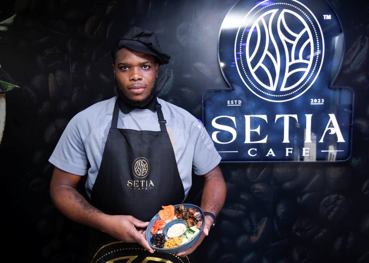 Chef Johnaton Grant poses with the basmati rice bowl featuring the signature jerk chicken.