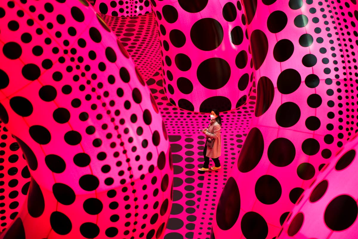 A woman walks through the artwork ‘A Bouquet of Love I Saw in the Universe’ by Yayoi Kusama during the press preview of a retrospective exhibition of the Japanese artist at the Martin Gropius Bau museum in Berlin, Germany, on April 22, 2021. 