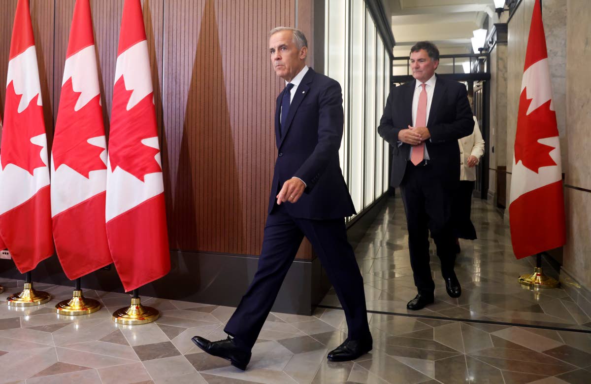 Prime Minister Mark Carney and Canada-U.S. Trade Minister Dominic LeBlanc arrive at a news conference about Canada’s response to new U.S. tariffs on Parliament Hill in Ottawa on Saturday, Aug. 22, 2026. (Patrick Doyle/The Canadian Press via AP)