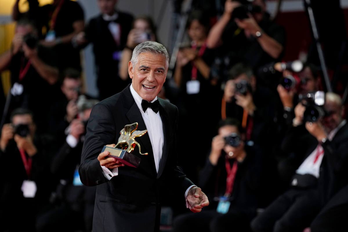 Hollywood star George Clooney poses with the prestigious Golden Lion for Lifetime Achievement during the 83rd Venice Film Festival in Venice, Italy, on Wednesday. 