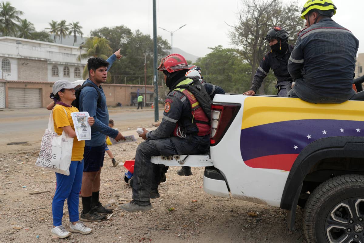 Pedro Gomez asks rescuers for information about his cousin, Andres Molina, who has been missing since the earthquake, in La Guaira, Venezuela, last month.