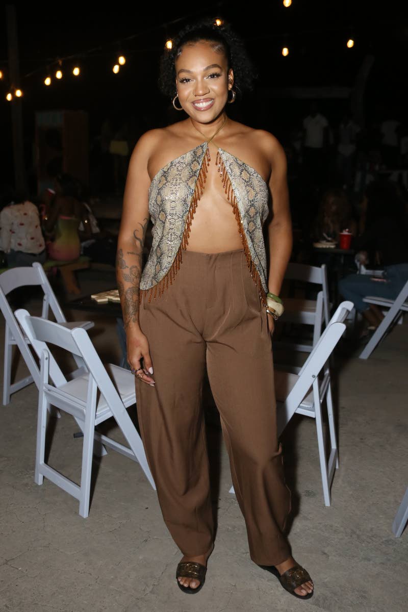 Left: TV host Ashley Miller turns up the heat in earthy tones, pairing a daring snakeskin-print scarf top with relaxed brown trousers.
