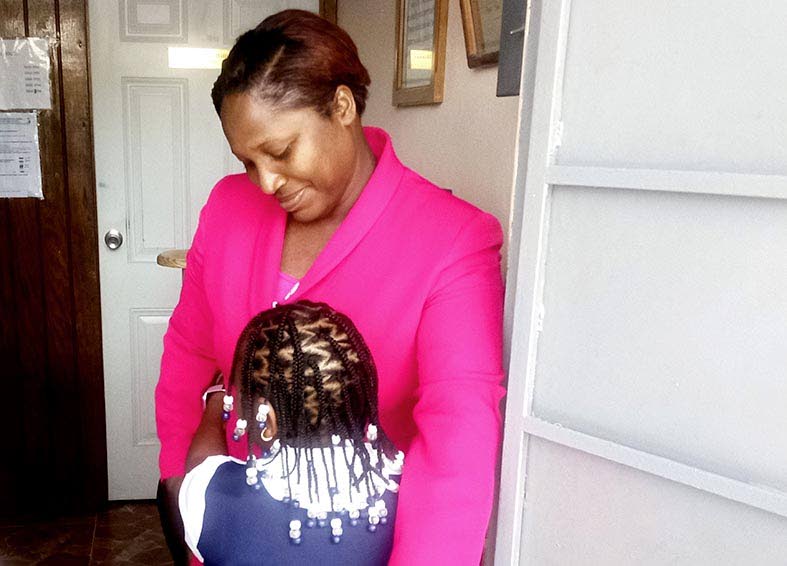 Port Antonio Primary School Principal Kennecha Davis-Williams shares a hug with one of her students during the reopening of school.