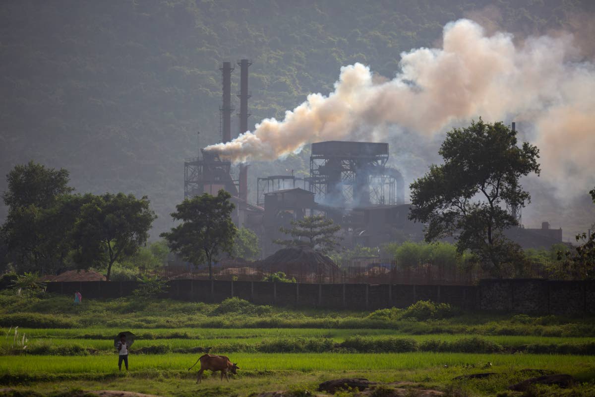 FILE – Smoke rises from a coal-powered steel plant at Hehal village near Ranchi, India, in eastern state of Jharkhand, September 26, 2021. 