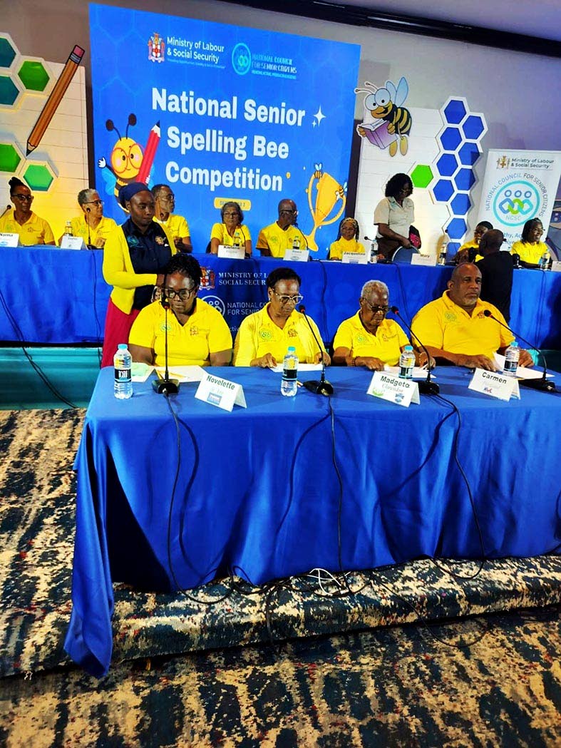 Madgeta Pinto (second left) participates in the National Senior Citizens’ Spelling Bee competition at the Jamaica Pegasus hotel in New Kingston last Thursday. Looking on is Toshane Young, Clarendon parish organiser with the National Council for Senior Ci