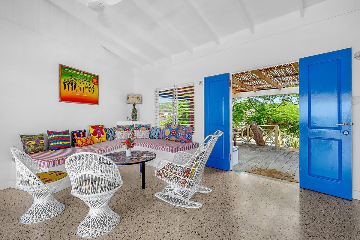 A simply designed and furnished living area opening wide to the outdoors. 