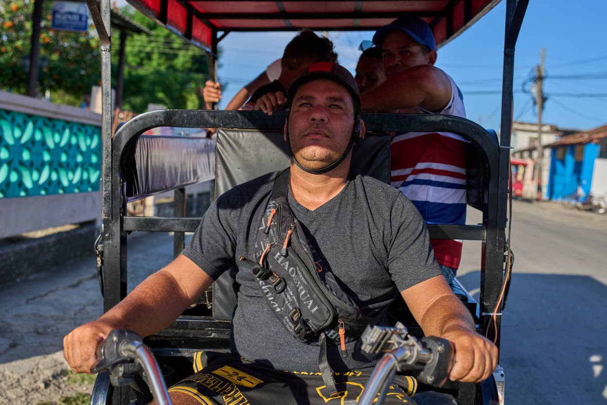 
Liexer De La Cruz drives his tricycle with customers in Minas, Cuba’s Havana province, September 4.