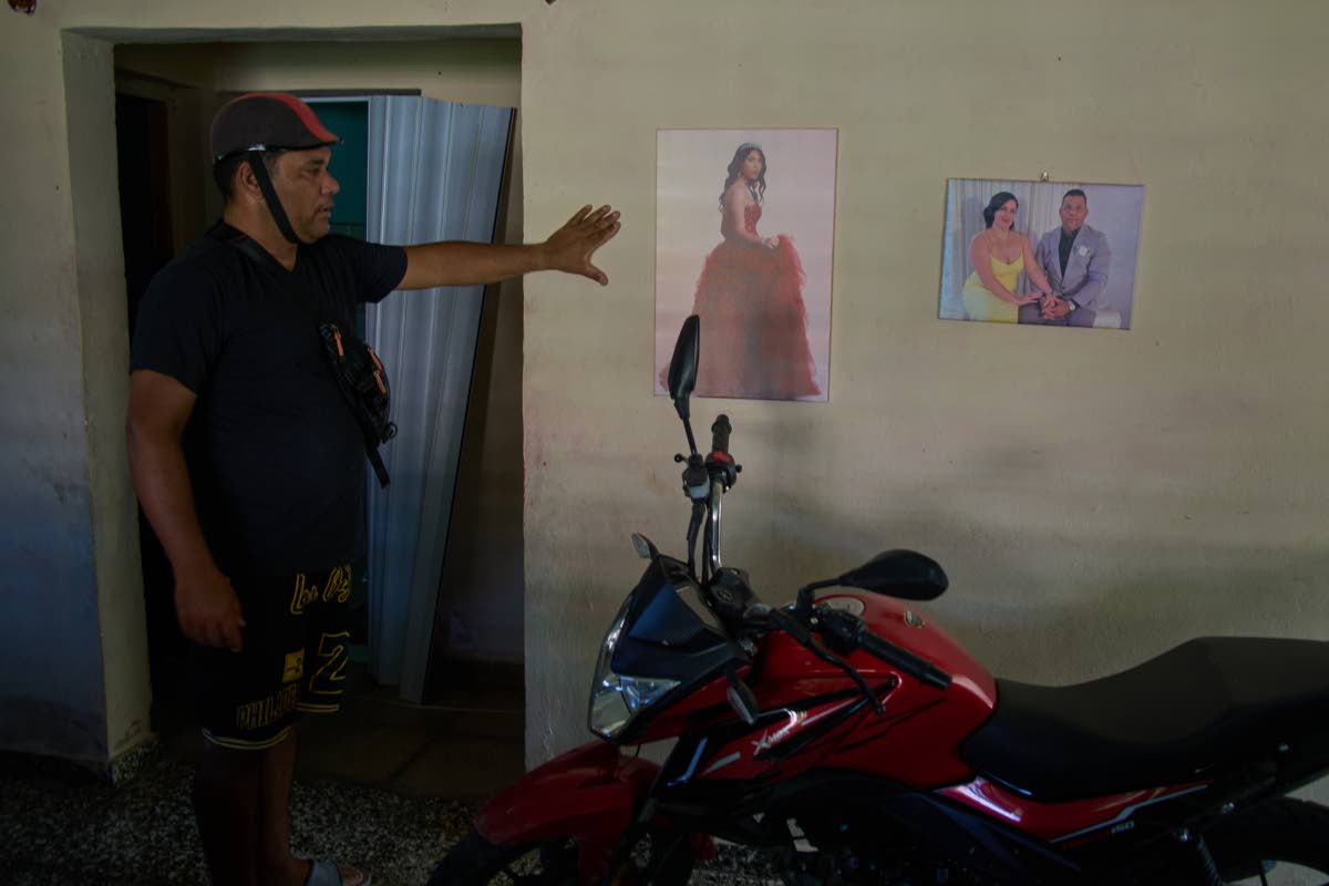 Liexer De La Cruz shows a photo of one of his daughters’ 15th birthday and a photo with his wife taken at a friends’ wedding in the United States.