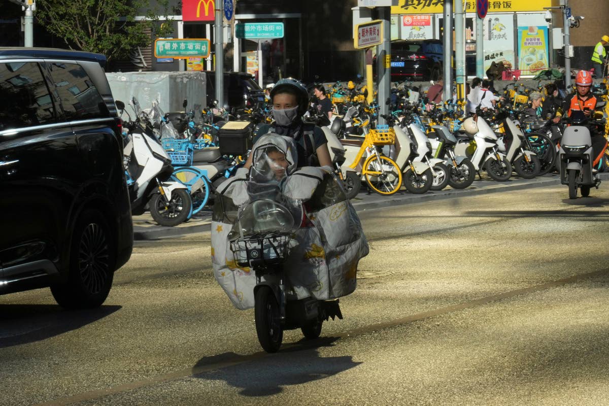 A woman ride an electric bike in Beijing.