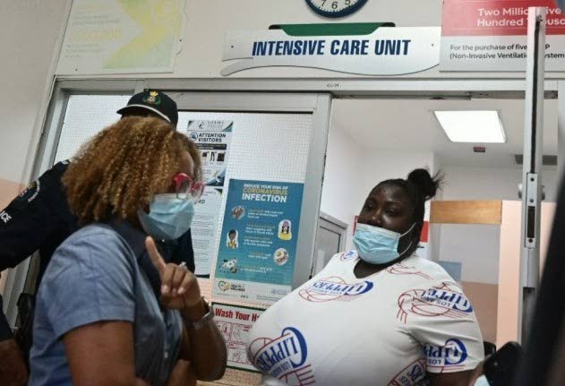 Minister of Education, Skills, Youth and Information, Senator Dr Dana Morris Dixon (left) shares in conversation with the mother of a child who was severely injured after a boulder fell on her on Friday, September 11, while on her way to school in Breadnut