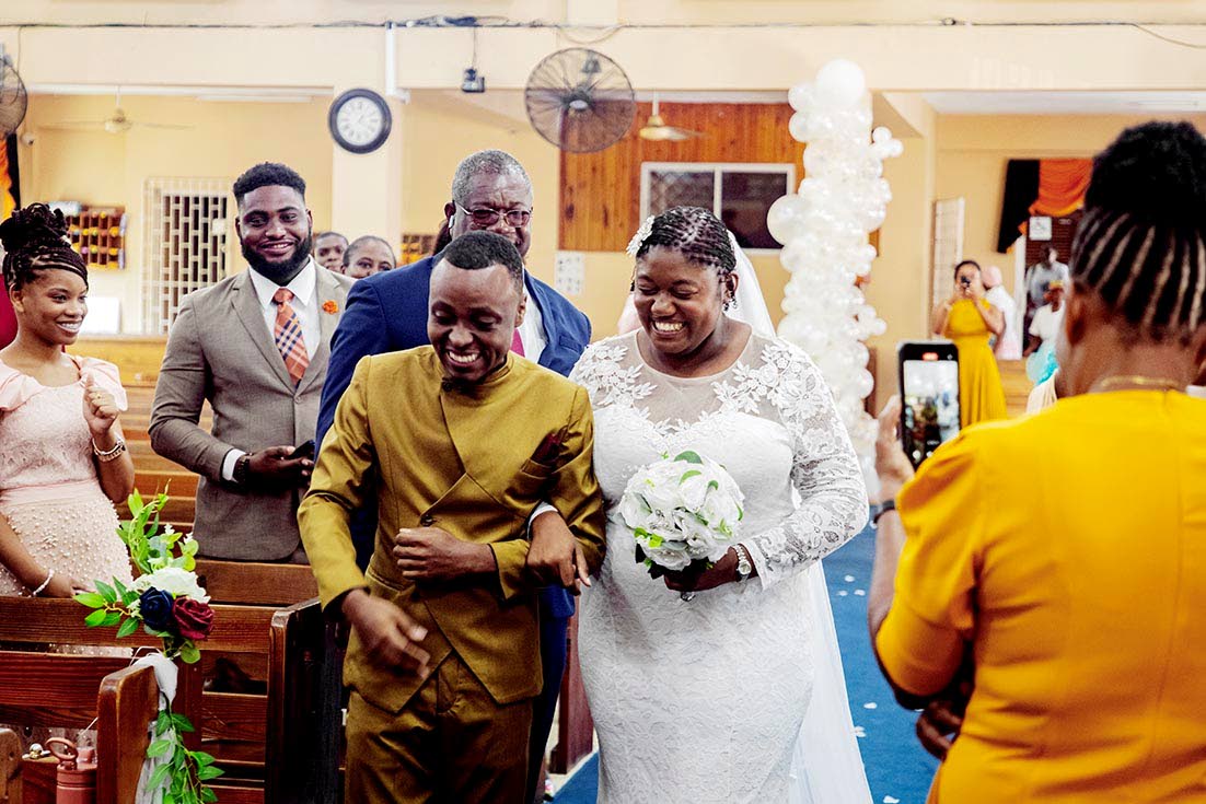 Following the ceremony, newly-weds Tadjé and Patrice Dixon take their first walk as husband and wife.
