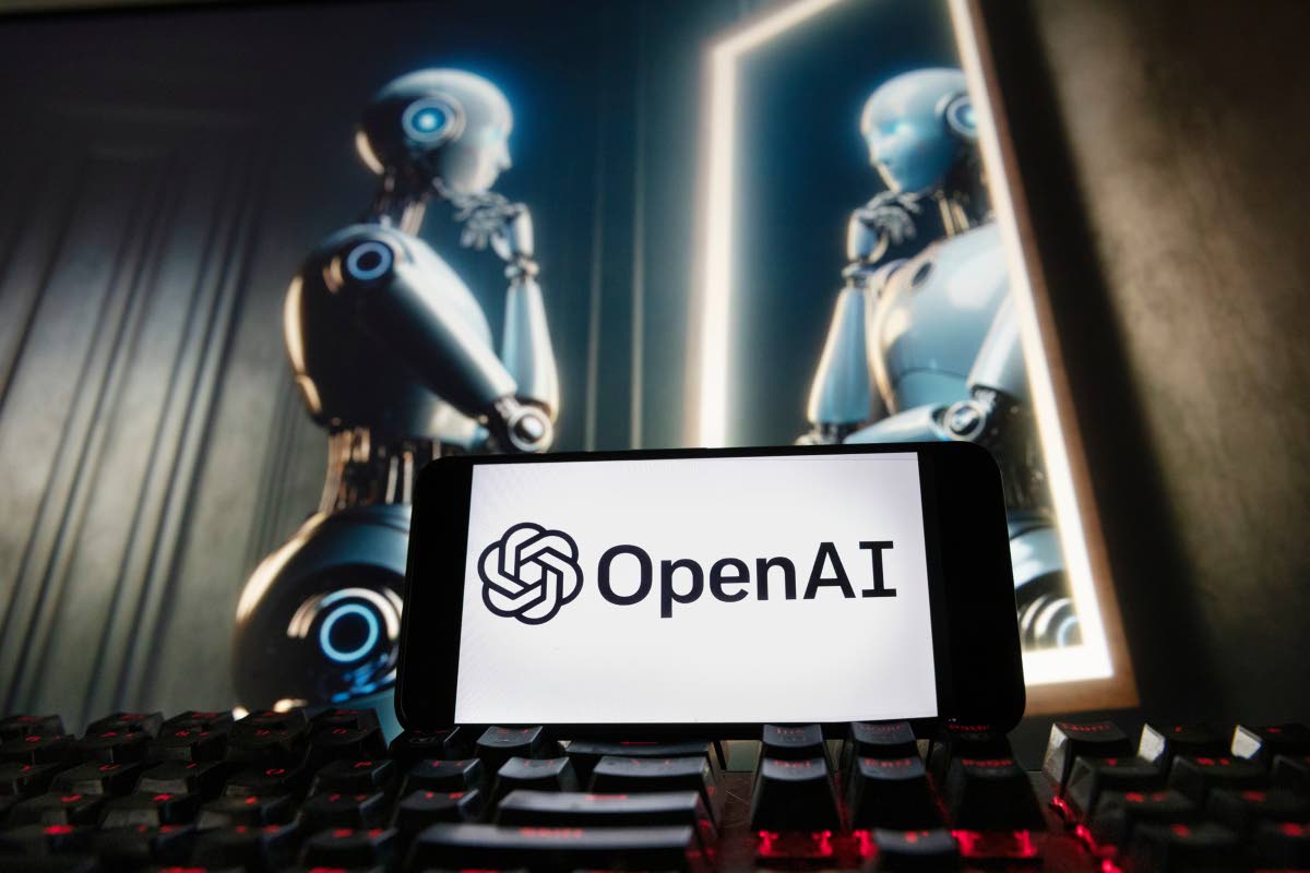 The OpenAI logo is displayed on a cell phone with an image on a computer monitor generated by ChatGPT's Dall-E text-to-image model on December 8, 2023 in Boston.  AP 