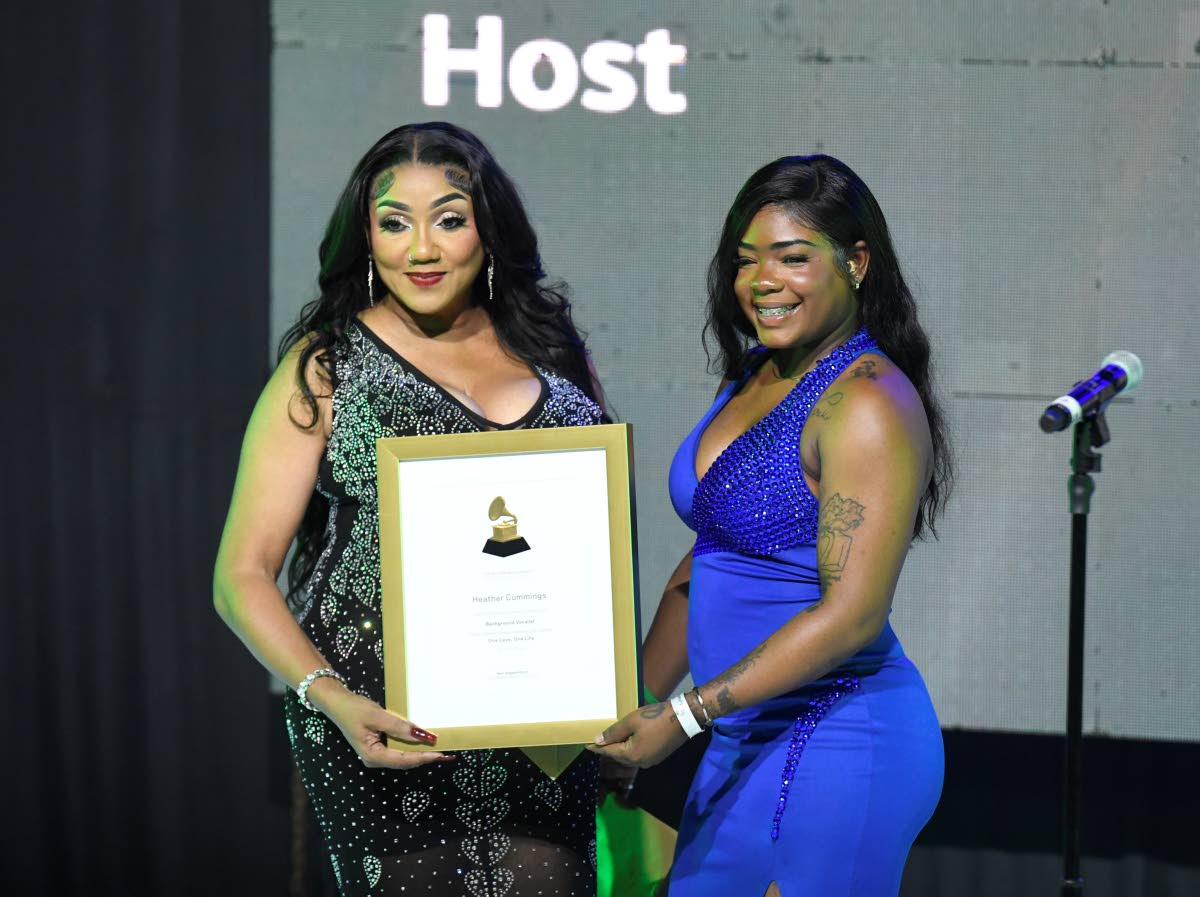 A happy Heather Cummings (left) collects her Grammy Certificate for background vocals on Beres Hammond’s ‘One Love, One Life’. Ashakay Campbell, Incognito Vacation Stays, makes the presentation.
