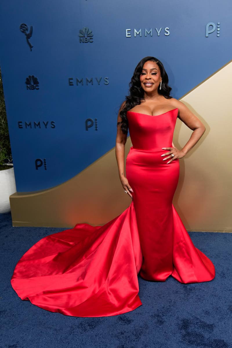 Niecy Nash-Betts brings bombshell glamour to the blue carpet in a custom scarlet Khaled & Marwan gown. The strapless, corseted design was finished with a dramatic train. 