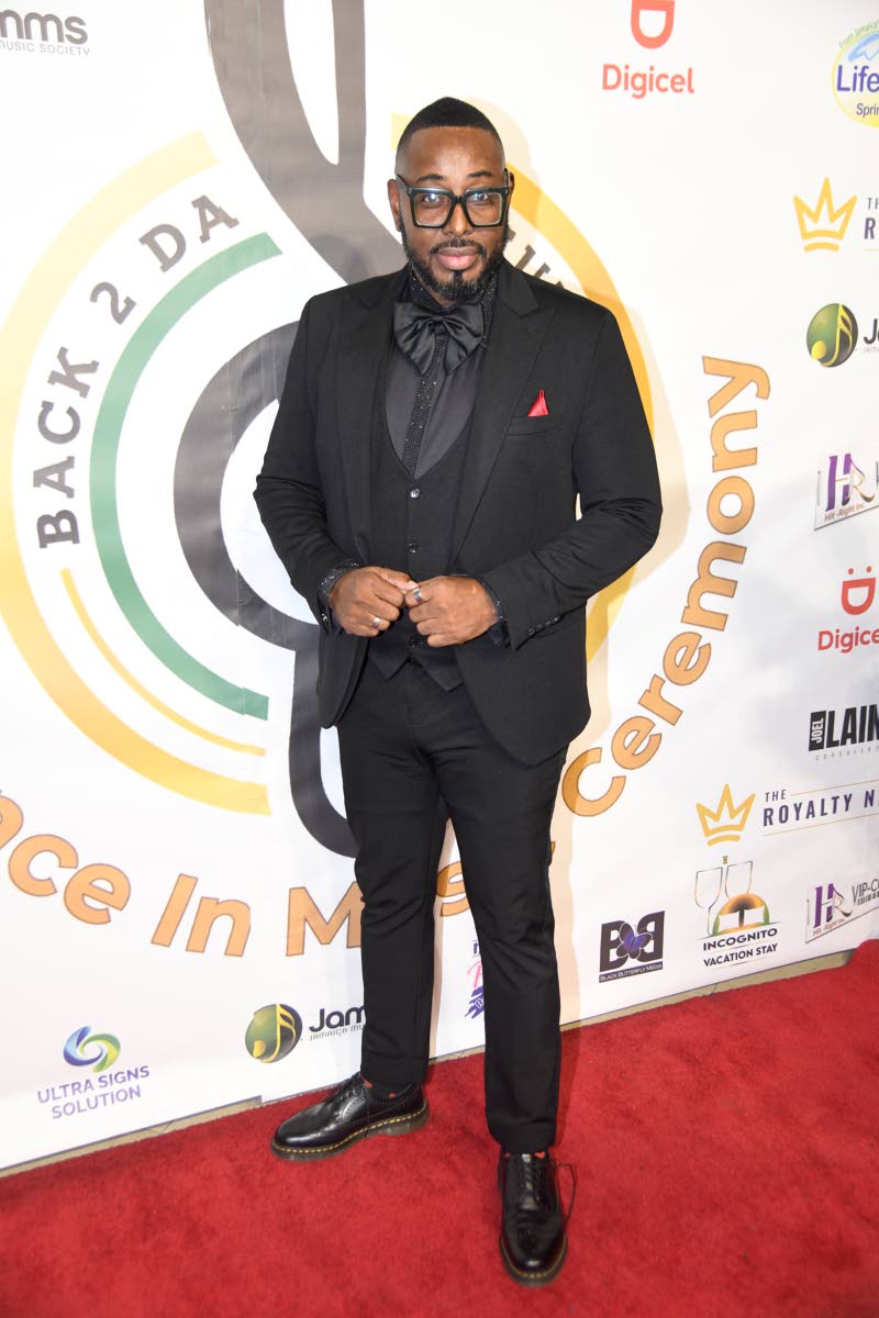 Attorney-at-law Ewan Simpson opts for a polished black three-piece suit, finished with a red pocket square.
