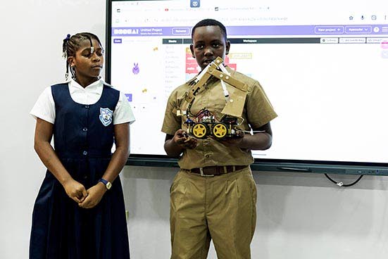 Anchovy Primary School students Rosanna Murray and Allandre Ellis demonstrate a robot they built and explain how it works, showcasing the school’s growing interest in coding and robotics. 