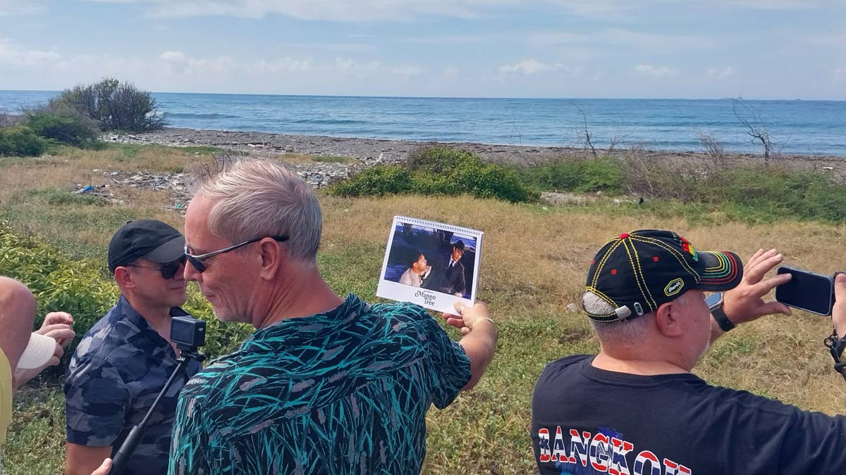 Martijn Mulder (centre) shows the group a screenshot from ‘Dr No’ at a location just off the Port Royal Main Road where the scene was filmed.