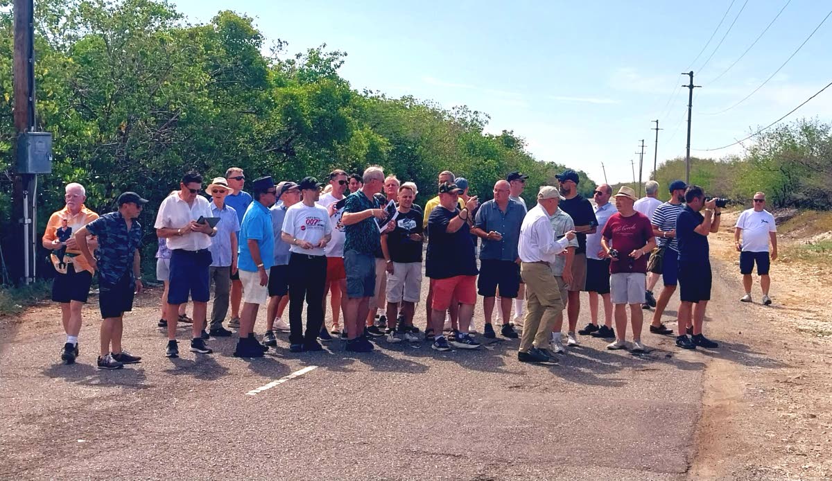 James Bond enthusiasts gather along the Port Royal Main Road, with publisher and tour leader Martijn Mulder (centre) holding an image folder as he guides the group through Jamaica’s 007 history.