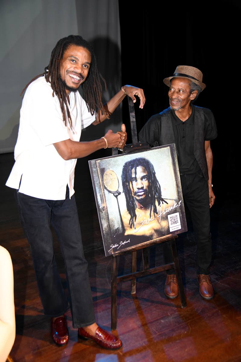 Sheldon Shepherd (left) and his father, Keith Anthony Shepherd, pose beside an easel displaying the cover of Shepherd’s debut solo album, ‘Give Thanks’.