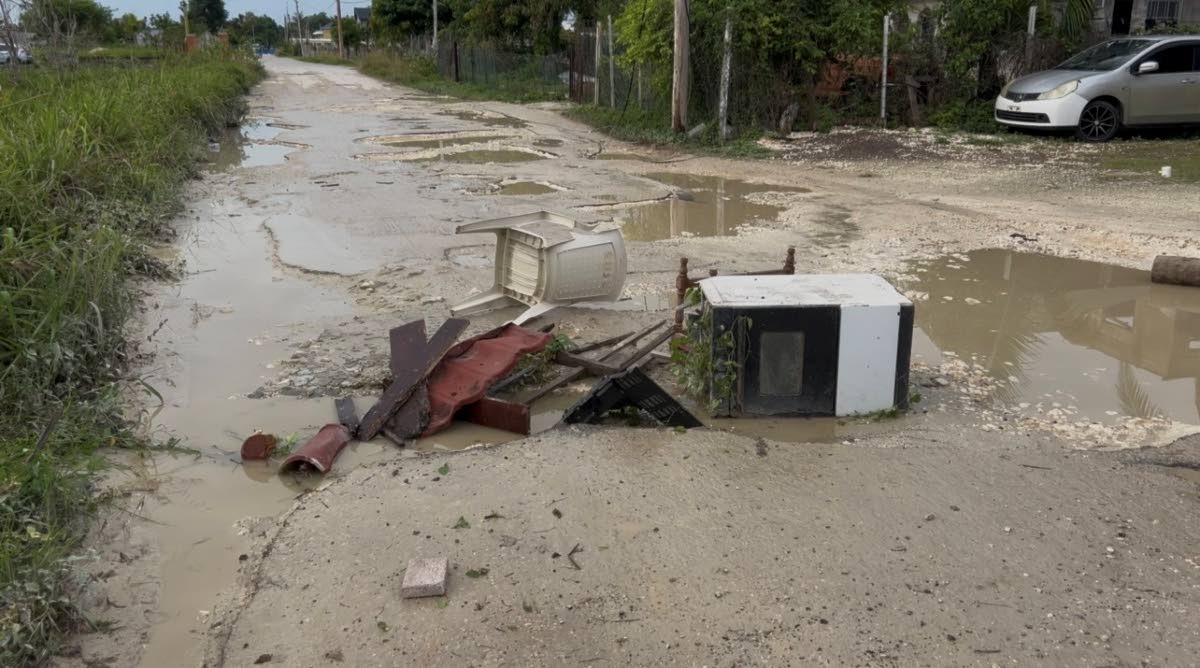 Residents block a section of the roadway in Hertford, Westmoreland, on Tuesday, the second day of protests demanding urgent repairs to the badly deteriorated roads.