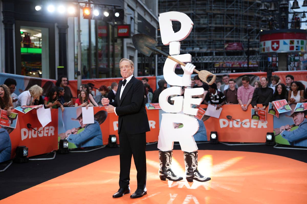John Goodman adjusts the cuffs of his classic black tuxedo.