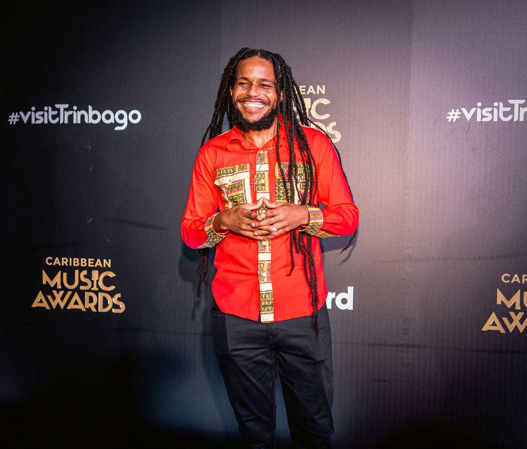 Ras-I steps out in a red long-sleeve traditional shirt paired with black trousers.