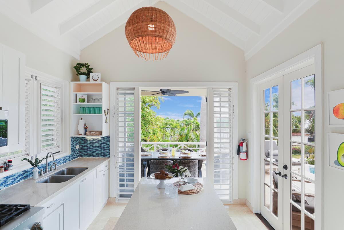 
An island kitchen opens fully to both indoor and outdoor living spaces.