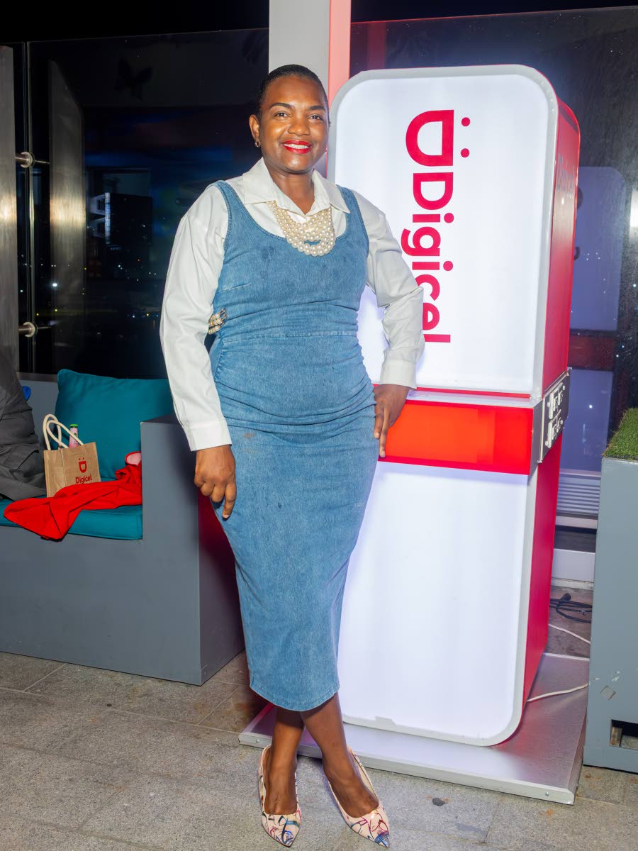 Fedora Bailey, senior manager of direct sales at Digicel, pairs a denim dress with a white button-down, pearls and patterned pumps.
