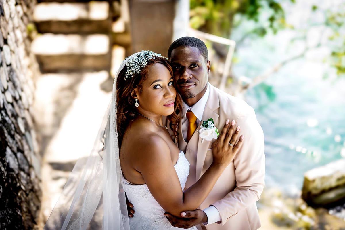 With the Caribbean Sea as their scenic backdrop, Arthur and Camille share a loving embrace.