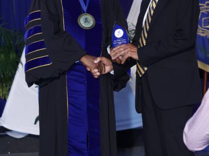 Professor Lincoln Edwards (left), president of Northern Caribbean University, presents the Product Sample award to Pastor Howard Holmes.