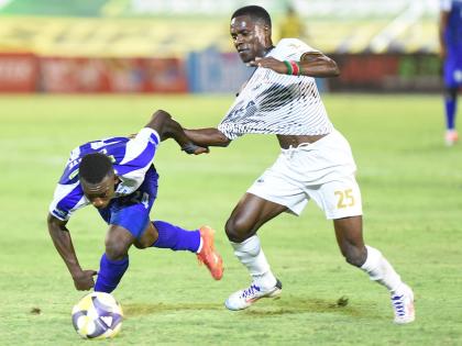 
Franco Celestin (left) from Mount Pleasant tugs on the shirt of Jahmilio Rigters from Cavaliers during action from last season’s Jamaica Premier League final at the National Stadium.