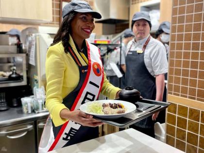 Jamaican Ambassador to Japan Shorna-Kay Richards serves up an order of jerk chicken at Matsuya.