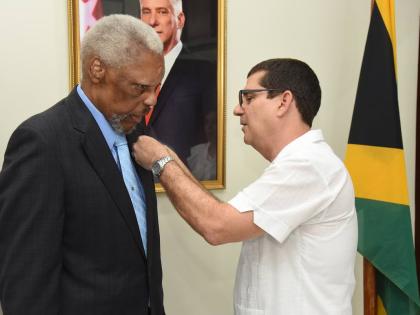 Cuban Ambassador Fermín Quiñones pins Errald Miller, husband of former Pime Minister Portia Simpson Miller, with the Cuban Medal of Friendship, one of Cuba’s highest honours for foreign leaders who have supported the country.