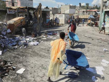 Youths use wheelbarrows to carry debris out of their homes, which were damaged by gang violence, in the Solino neighbourhood of Port-au-Prince, Haiti, Wednesday, September 10, 2025. (AP Photo/Odelyn Joseph)