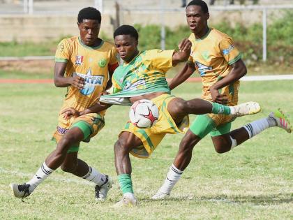 Excelsior High School’s Kimarly Scott (centre) has his shirt tugged by St Jago’s Jordon Taylor while attempting to kick during their ISSA/WATA Manning Cup football Game at the Courtney Walsh Oval yesterday. That game ended 0-0.