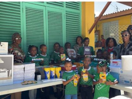 Retired educator Rhona Campbell (left), Dr Dawn Lemonius (second right) and retired Assistant Commissioner of Police Denver Frater (right) were all smiles as they handed over goodies to staff and students at the Ulster Spring Primary and Infant School.