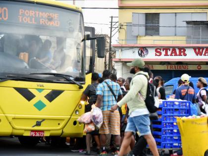 In this file photo commuters are seen jostling to board a Jamaica Urban Transit Company bus at the South Parade terminus in downtown Kingston.