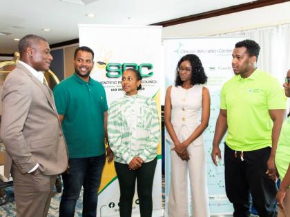 From left: Carlinton Burrell, CEO of the Caribbean Climate Innovation Centre (CCIC), addresses the winners of the ScaleItUp Accelerator Demo Day pitch competition. John Mark Clayton and Kerri Anne Gray (Towerfarms Limited), Joanna Anderson (Phinetic) and D