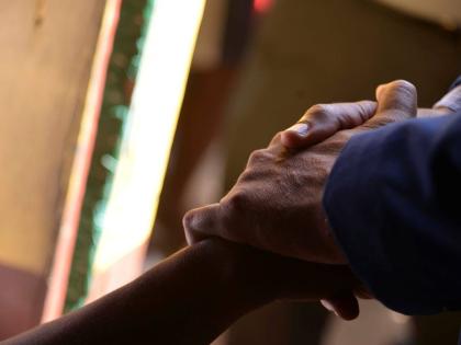 Prime Minister Dr Andrew Holness holds the hand of a grieving woman who lost her niece along the Commodore Road in Linstead, St Catherine, on October 6, where nine persons were shot by gunmen, five fatally on October 5. 