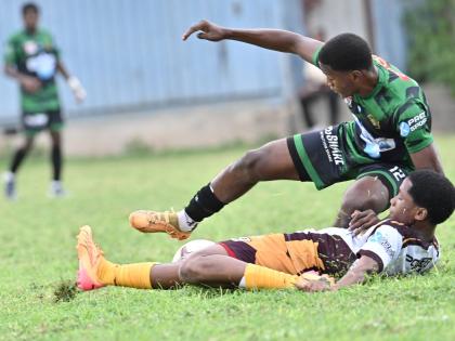 Calabar’s Kimani Thompson is felled by a cruching challenge from Wolmer’s Boys’ School’s D’Andre Campbell during their ISS/WATA Manning Cup Zone E playoff clash at the Mico University yesterday.