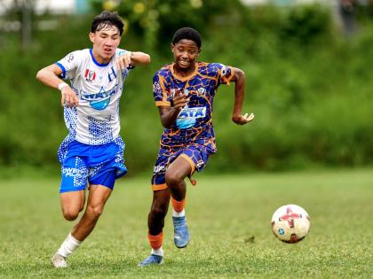 Hillel Academy’s Miles Azan (left) and Dunoon Technical’s Shiloh Roach chase the ball during an ISSA/WATA Manning Cup football match at on September 27. Hillel won 3-2.