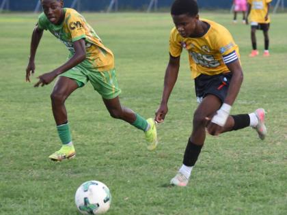 York Castle High School’s Chadoye Higgins (right) tries to outrun Ocho Rios High School’s Ryan Francis during their ISSA daCosta Cup Zone K match at the Drax Hall Sports Complex yesterday.