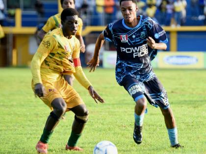 The Manning’s School’s Devardo Reid (right) tries to dribble past BB Coke captain, Yandria Morgan during thir Group 3 ISSA daCosta Cup second round game at the STETHS Sports Complex yesterday.