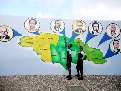 In this file photo, Akaycia Brown (left) and Melecia Bennett stand in front of a mural of map of Jamaica and the country’s National Heroes.