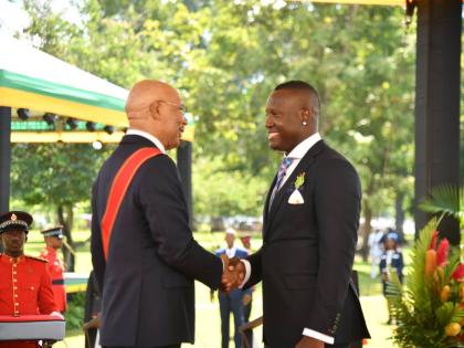 Former West Indies captain Rovman Powell shakes the hand of Governor General Sir Patrick Allen after getting pinned at the Ceremony of Investiture and Presentation of National Honours and Awards on the lawns of King’s House yesterday.