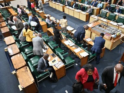 Members of the parliamentary Opposition gather their belongings as they walked out of Gordon House on Tuesday in protest after House Speaker cut Opposition Leader Mark Golding’s microphone.