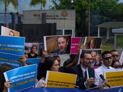 Gabriel Cabrera, president of the Venezuelan Youth Center for Democracy, gives a statement outside of the US embassy with members of the organisation holding signs against US intervention, in reference to US warships operating in the Caribbean, in Caracas,