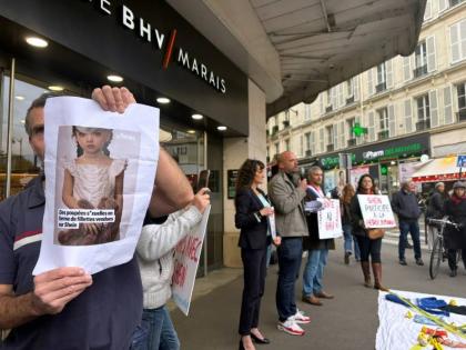 A protester holds a picture of a childlike sex doll outside BHV Marais department store in Parish, Monday, November 3, 2025, where Shein is due to open its first permanent physical store worldwide. (AP Photo/Nicholas Garriga)