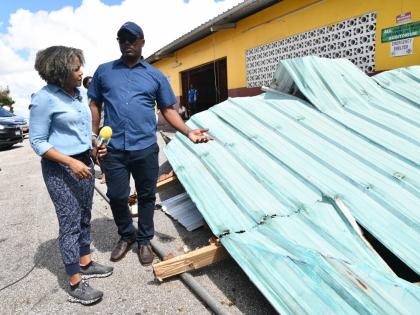 Minister of Education, Skills, Youth and Information, Senator Dr Dana Morris Dixon (left), listens to Hidran McKulsky, principal of Manchester-based Holmwood Technical High School, while on a visit to the institution on Sunday to see the extent of the hurr